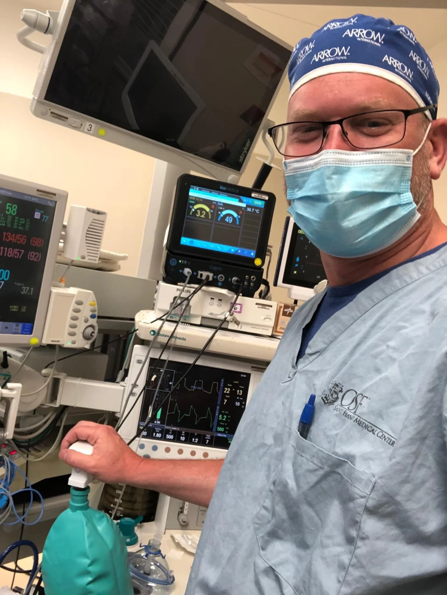 Dr. Bill Hauter in scrubs beside anesthesia monitors in an operating room